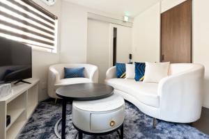 uma sala de estar com um sofá branco e uma mesa em Hotel kiki em Osaka