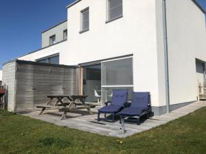 a patio with two chairs and a picnic table in front of a building at Sea-Senses.com/Blue LaGoon in Oostduinkerke