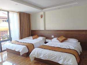 een hotelkamer met 2 bedden en een raam bij Orchids Hotel in Sa Pa