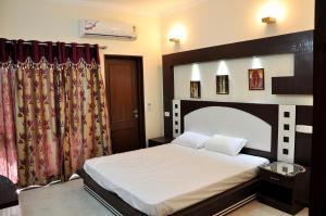 a bedroom with a bed with a large headboard and curtains at Mohini Home Stay in Agra