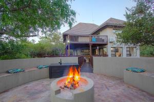 a fire pit in a yard in front of a house at Call of the Fish Eagle Self-catering Holiday Home with solar in Marloth Park
