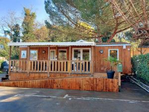里夫杜海滩Camping 4 étoiles Les Fougères的小木屋设有门廊和围栏