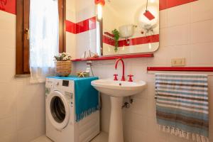 bagno con lavatrice e lavandino di SARDINIA RE - Villino Punta Negra a Stintino