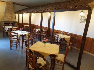 a restaurant with tables and chairs and a fireplace at Oasi del benessere in Ilbono