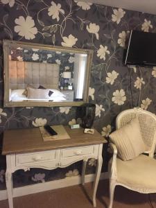 a bedroom with a desk and a mirror and a bed at Castle Lodge Wilton in Ross on Wye