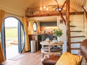 eine Küche und ein Wohnzimmer in einem winzigen Haus in der Unterkunft Wrekin Lodge in Much Wenlock