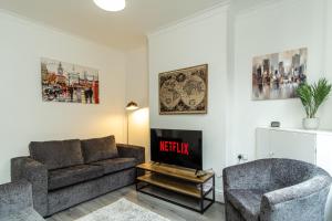 a living room with a couch and a chair at Enfield House in Coventry