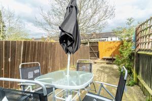 an umbrella sitting on a table in a backyard at Enfield House in Coventry