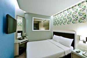 a hotel room with a bed and a window at Prestige Suites Nana in Bangkok
