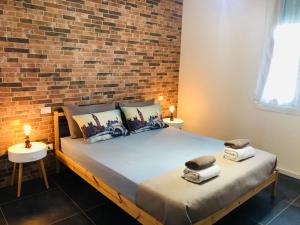 um quarto com uma cama com uma parede de tijolos em BLAXEJ, nel cuore di Verona, MODERNO ed ELEGANTE, 4 posti letto, Wi-Fi, Self Check In em Verona