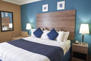 1 dormitorio con 1 cama grande y pared azul en Seaport Resort and Marina en Fairhaven