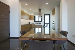 eine Küche und ein Esszimmer mit einem Holztisch und Stühlen in der Unterkunft Phaedrus Living: Sea View Anna Residence 302 in Limassol