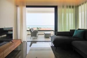 ein Wohnzimmer mit einem Sofa und einem großen Fenster in der Unterkunft Phaedrus Living: Sea View Anna Residence 302 in Limassol