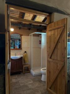 a bathroom with a wooden door and a toilet at Rodous Village House in Limassol