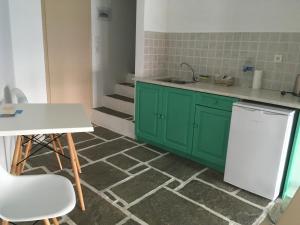 a kitchen with green cabinets and a white refrigerator at Kifines Suites in Chora Folegandros