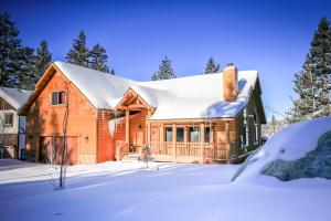 una baita di tronchi nella neve coperta da neve di Eagle Ridge Views-1648 by Big Bear Vacations a Big Bear Lake