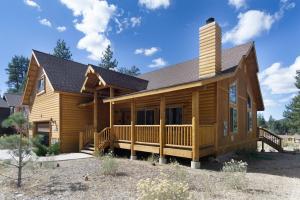 una casa di tronchi con portico e camino di Eagle Ridge Views-1648 by Big Bear Vacations a Big Bear Lake