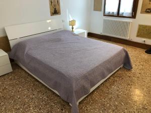 sypialnia z dużym łóżkiem i szarym kocem w obiekcie Casa Regini Venezia w Wenecji