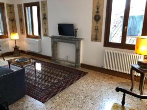 salon z kominkiem i telewizorem w obiekcie Casa Regini Venezia w Wenecji