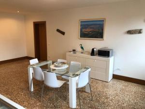jadalnia ze szklanym stołem i białymi krzesłami w obiekcie Casa Regini Venezia w Wenecji