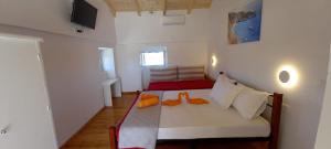 KypseliにあるVilla Beloussi Zakynthosのオレンジの靴が付いたベッドが備わる客室です。