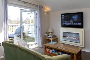a living room with a couch and a tv at Carnoustie Dreams in Wisbech