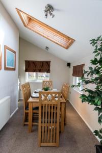 een eetkamer met een houten tafel en stoelen bij Carnoustie Dreams in Wisbech