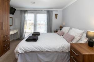 a bedroom with a white bed with two towels on it at Carnoustie Dreams in Wisbech
