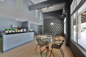 Un restaurante con mesas y sillas y un mostrador. en The Bless Residence, en Hat Yai