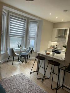 una cucina con sedie, tavolo e bancone di No 73 Aparthotel a Cambridge