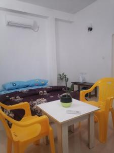 a room with a table and yellow chairs at The Rose Garden House in Hithadhoo