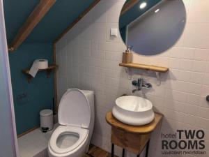 a bathroom with a toilet and a sink and a mirror at Kera2Rooms in Mtskheta
