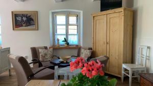 a living room with a table and chairs and a cabinet at Pension Laura in Chřibská
