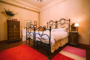 a bedroom with a large bed and a red rug at Palazzo Romani Adami in Fermo