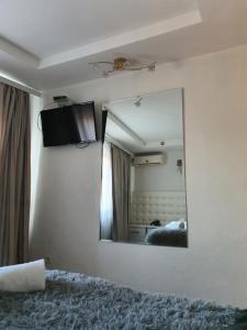 a mirror on the wall of a bedroom with a bed at Bella Donna Hotel in Chişinău