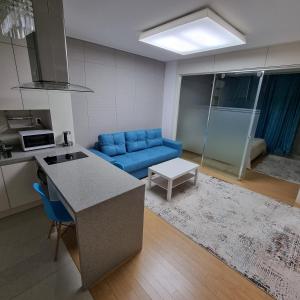 a kitchen and a living room with a blue couch at апартаменты в ЖК Хайвил in Astana