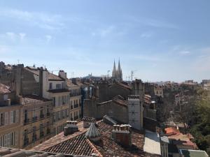 Blick auf eine Stadt mit Dächern und eine Kathedrale in der Unterkunft Grand studio avec vue sur notre Dame de la garde in Marseille