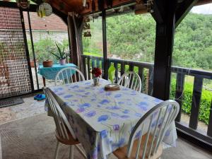 einen Tisch und Stühle auf der Veranda eines Hauses in der Unterkunft Val Paradis in Espagnac-Sainte-Eulalie