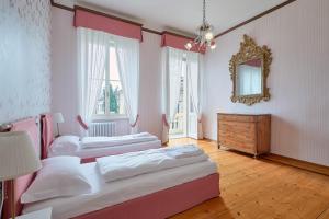 1 Schlafzimmer mit 2 Betten, einem Spiegel und einer Kommode in der Unterkunft Villa Brunelli in Riva del Garda