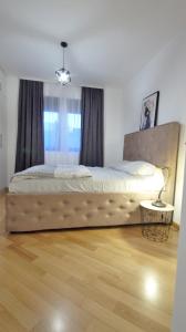 a large bed in a bedroom with a wooden floor at Comfy apartment - Sea View in Becici