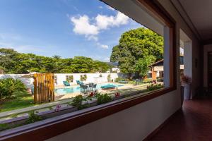 a window in a house looking out at a swimming pool at CASA DOM QUIXOTE, pequena Chácara no centro da cidade in Atibaia