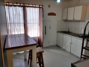 a small kitchen with a wooden table and a window at Duplex en el centro de Concepción del Uruguay in Concepción del Uruguay
