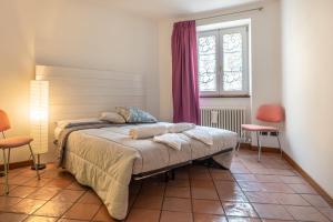 1 dormitorio con 1 cama, ventana y sillas en Casa Carraia, en Cembra