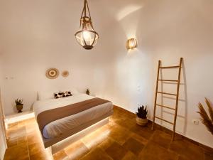 een slaapkamer met een bed en een ladder erin bij Esmi Cave Residence in Karterados