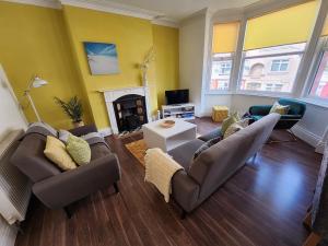 a living room with two couches and a fireplace at VICTORIA 24 in Llandudno