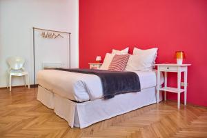 a bedroom with a large bed with a red wall at Al Cavour 34 in Trento
