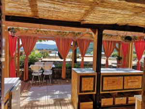 a patio with red curtains and a table and chairs at Gite Terradou in Planzolles