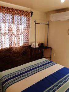 Schlafzimmer mit einem Bett mit einem Spiegel und einem Fenster in der Unterkunft Loreto La Regional in Loreto