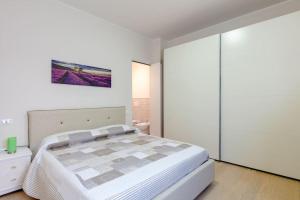 - une chambre avec un lit et une peinture murale dans l'établissement Via Roma 21, à Desenzano del Garda