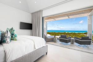 a bedroom with a bed and a view of the ocean at Beach Enclave in Providenciales